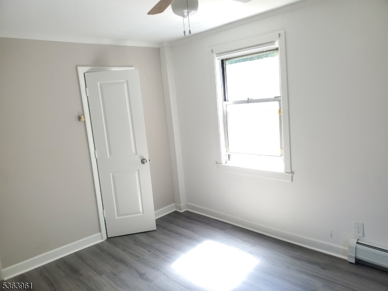 935 East Front Street, Unit C Plainfield, NJ 07062 - Photo 22 of 25 an empty room with wooden floor and windows