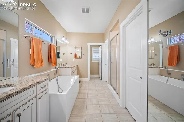 a bathroom with a tub sink and mirror