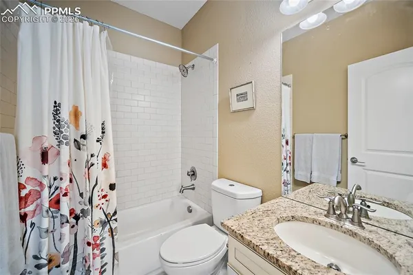a bathroom with a granite countertop sink toilet and shower