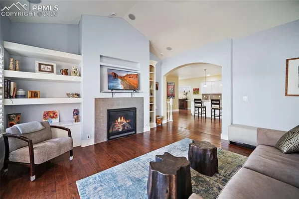 a living room with furniture fireplace and wooden floor