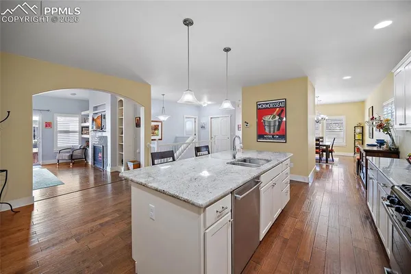 a open kitchen with stainless steel appliances granite countertop a kitchen island a refrigerator a stove and a sink with dishwasher
