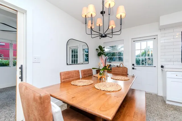 a view of a dining room with furniture a chandelier and wooden floor