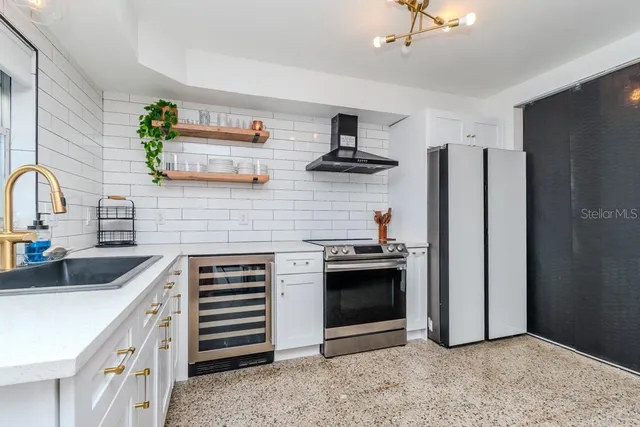 a kitchen with stainless steel appliances granite countertop a stove a sink and a refrigerator