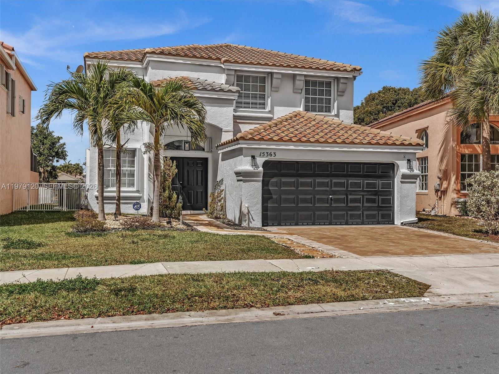 15363 Northwest 14th Road Pembroke Pines, FL 33028 - Photo 13 of 71 a front view of a house with a yard and garage