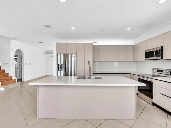 an empty room with staircase and ceiling fan