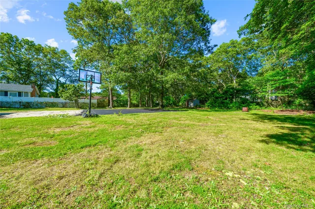 an aerial view of a house with garden space and trees all around