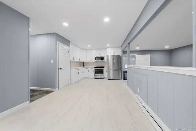 a large white kitchen with a refrigerator a stove and cabinets
