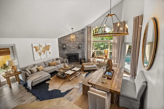 a living room with furniture a fireplace and a floor to ceiling window