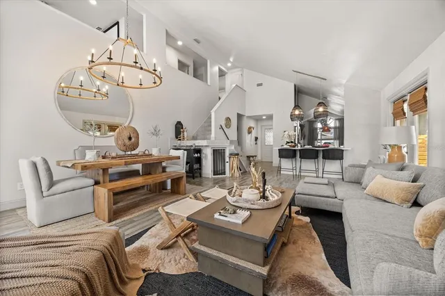 a living room with furniture a chandelier and a large window