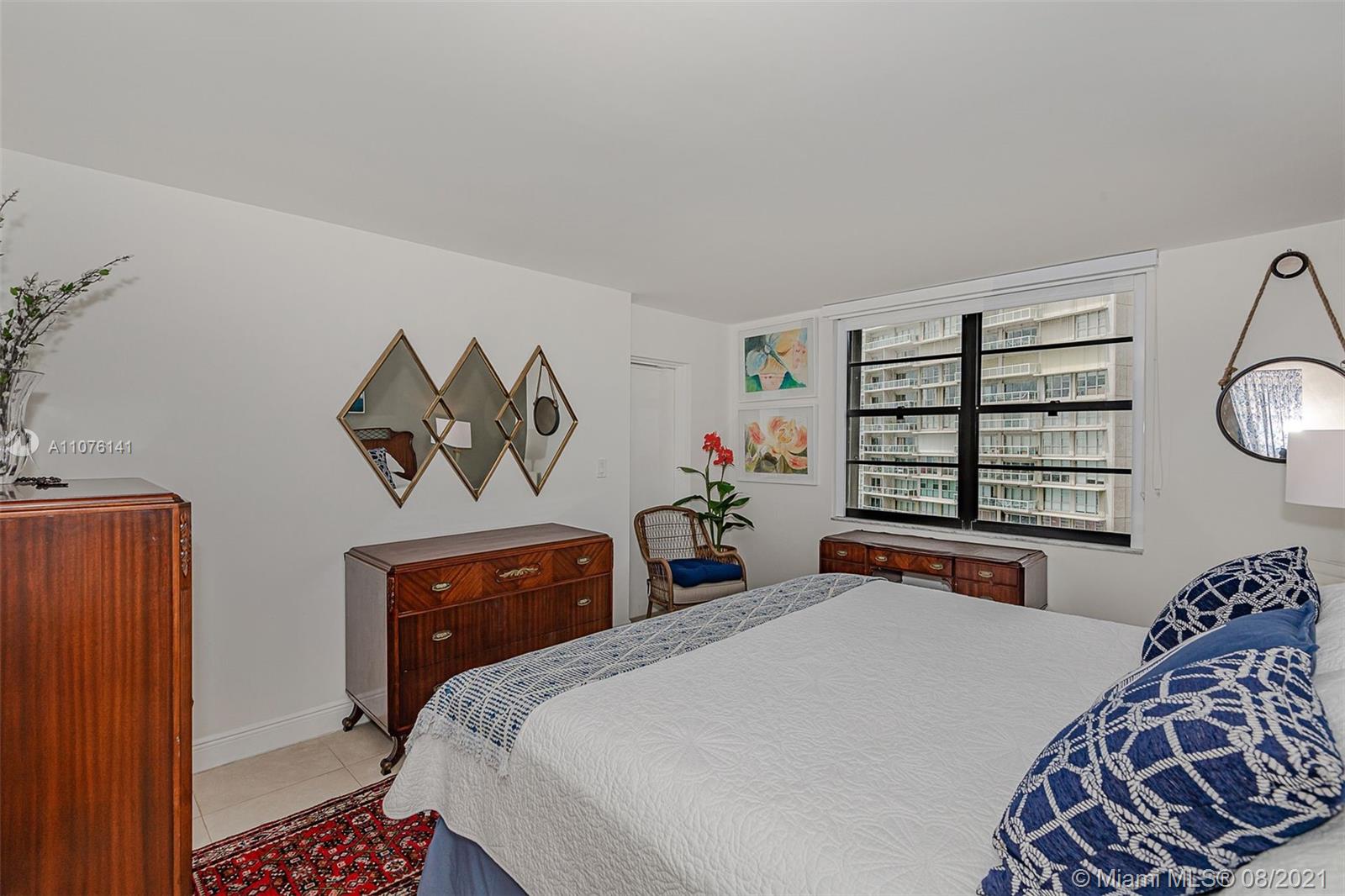 2333 Brickell Avenue, Unit 1406 Miami, FL 33129 - Photo 11 of 38 a bedroom with a bed and dresser with mirror