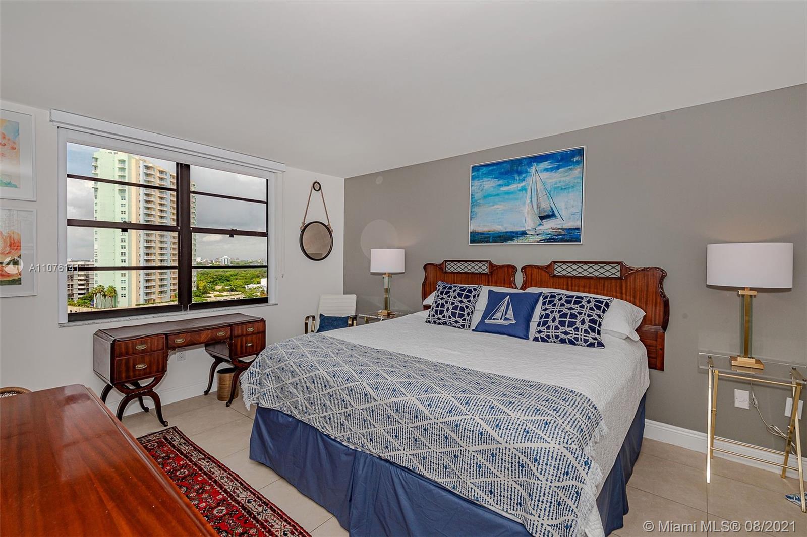 2333 Brickell Avenue, Unit 1406 Miami, FL 33129 - Photo 12 of 38 a bedroom with a bed and a table in it
