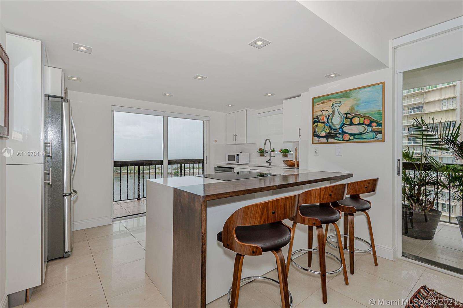 2333 Brickell Avenue, Unit 1406 Miami, FL 33129 - Photo 7 of 38 a kitchen with a table and chairs in it