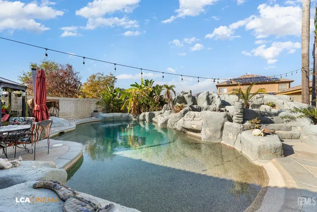 an aerial view of a house with swimming pool and a patio