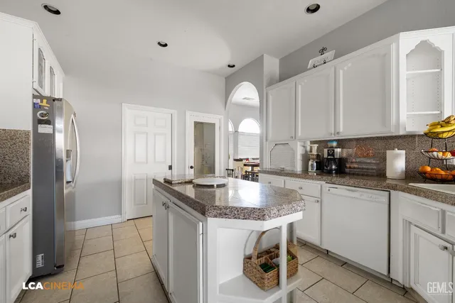 a kitchen with granite countertop a sink stove and refrigerator