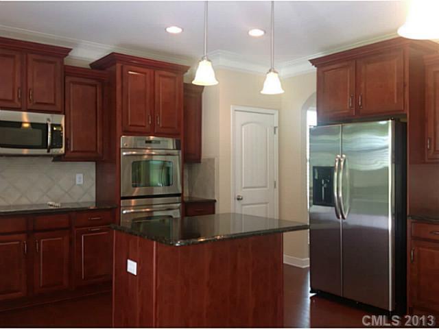 79091 Ridgehaven Road, Unit 164 Lancaster, SC 29720 - Photo 3 of 16 a kitchen with stainless steel appliances granite countertop a refrigerator a stove a sink and a microwave with wooden floor