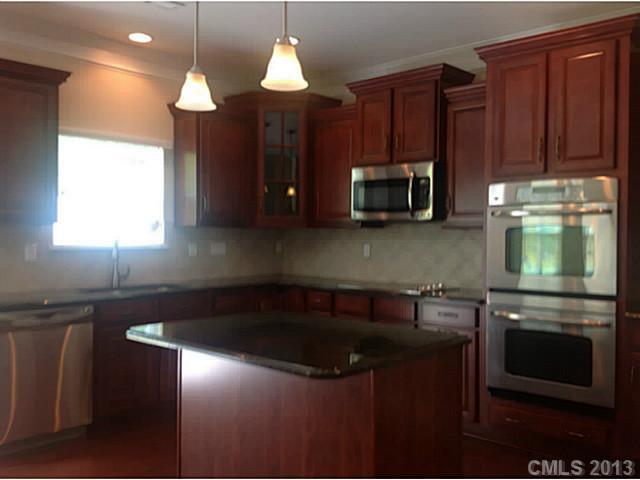 79091 Ridgehaven Road, Unit 164 Lancaster, SC 29720 - Photo 4 of 16 a kitchen with granite countertop a stove a sink and a microwave