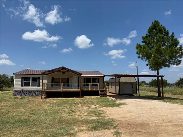 a view of a house with a backyard and a garden