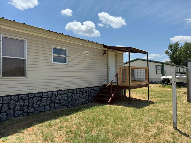 a backyard of a house with table and chairs