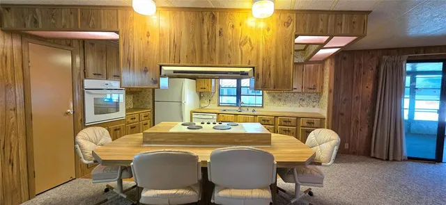 a view of a house with a big yard and large trees