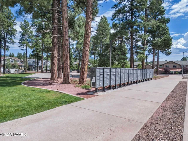 a kitchen with a refrigerator a stove top oven a sink dishwasher and white cabinets with wooden floor