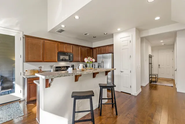 a bathroom with a granite countertop sink toilet a large mirror a shower and a bathtub