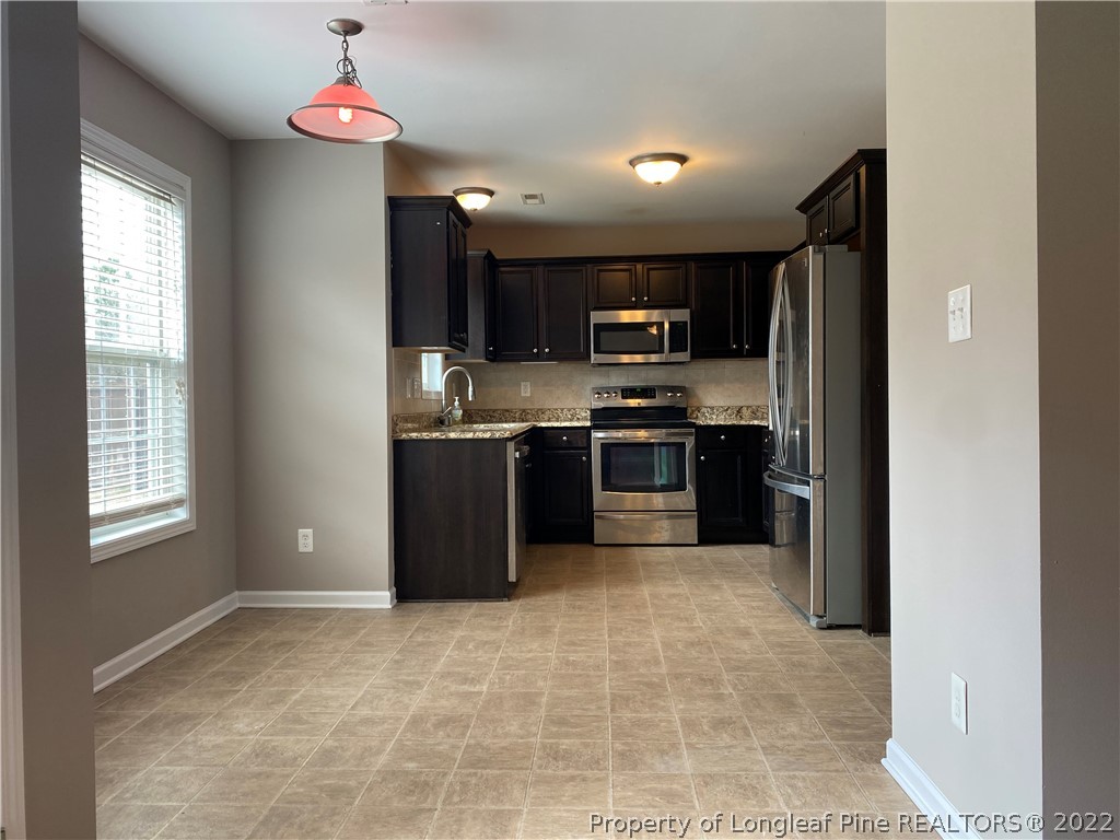 582 Cape Fear Road Raeford, NC 28376 - Photo 8 of 26 a large kitchen with cabinets and stainless steel appliances