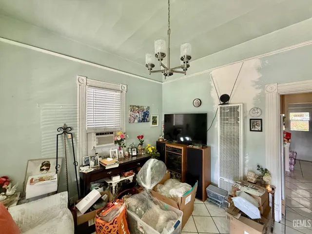 a living room with furniture a chandelier and a flat screen tv