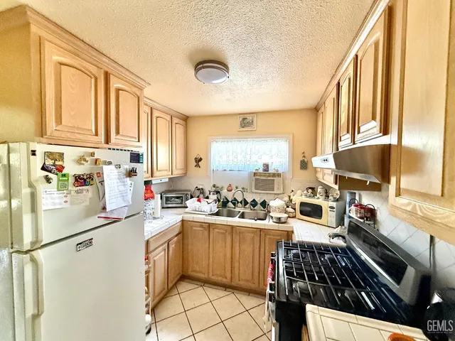 a kitchen with a sink appliances cabinets and a counter top space