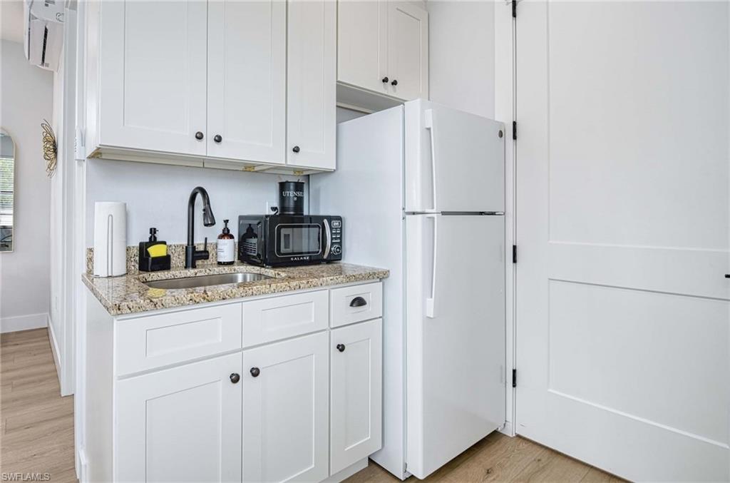 1147 Steeves Avenue Naples, FL 34104 - Photo 20 of 35 a kitchen with stainless steel appliances white cabinets and a refrigerator