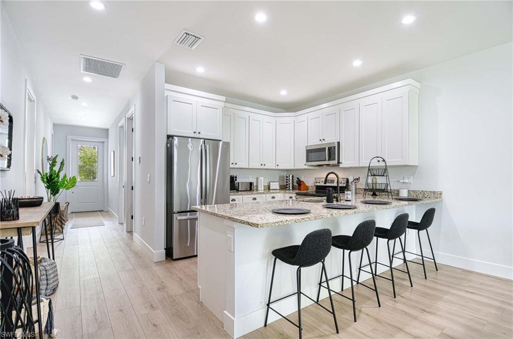 1147 Steeves Avenue Naples, FL 34104 - Photo 6 of 35 a kitchen with refrigerator and chairs