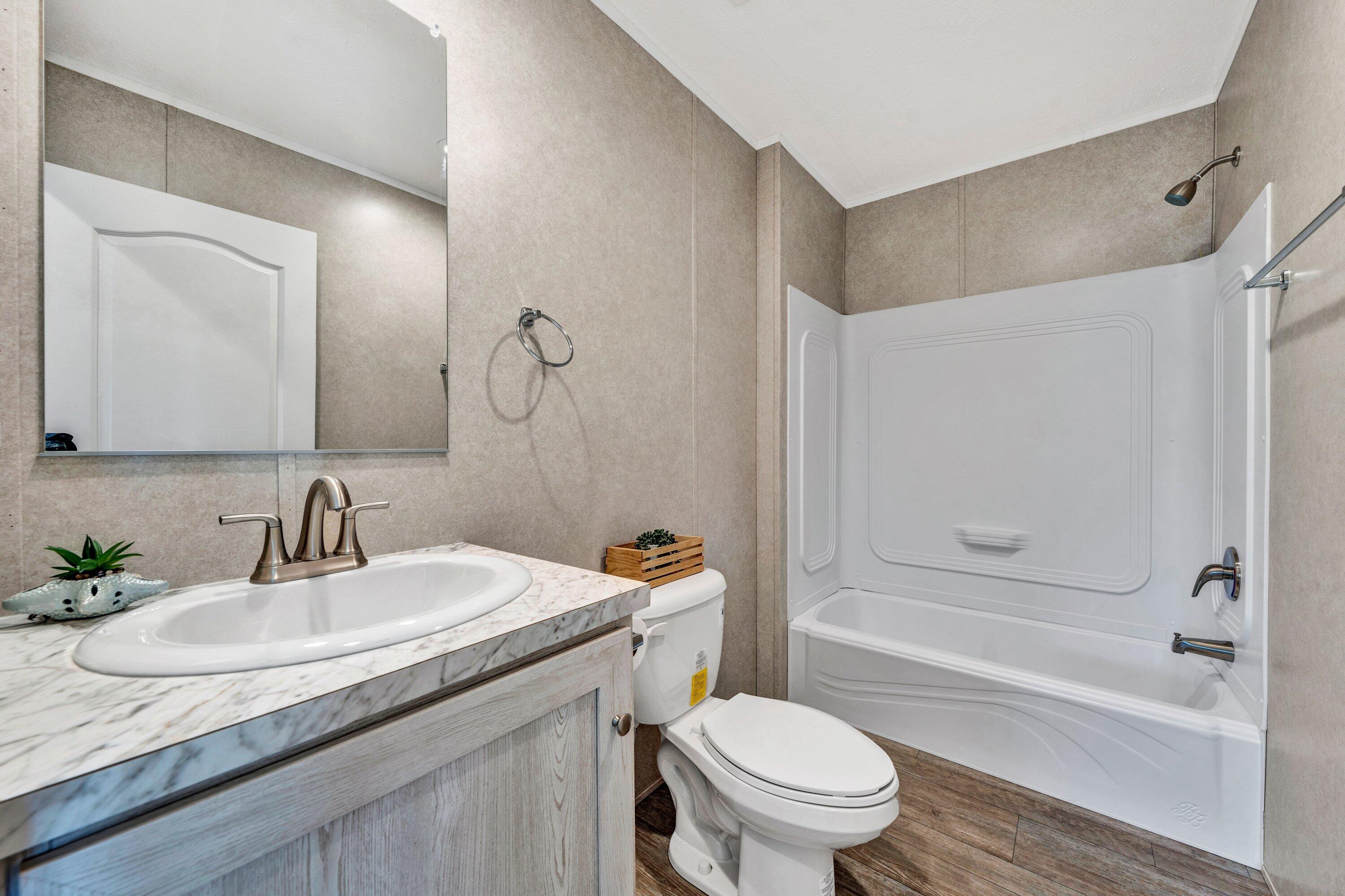 2098 Lipscomb Road Moneta, VA 24121 - Photo 13 of 27 a bathroom with a granite countertop sink a toilet and a bathtub