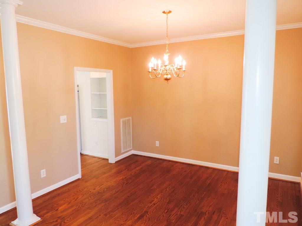 1901 Crag Burn Lane Raleigh, NC 27604 - Photo 2 of 16 an empty room with wooden floor and chandelier