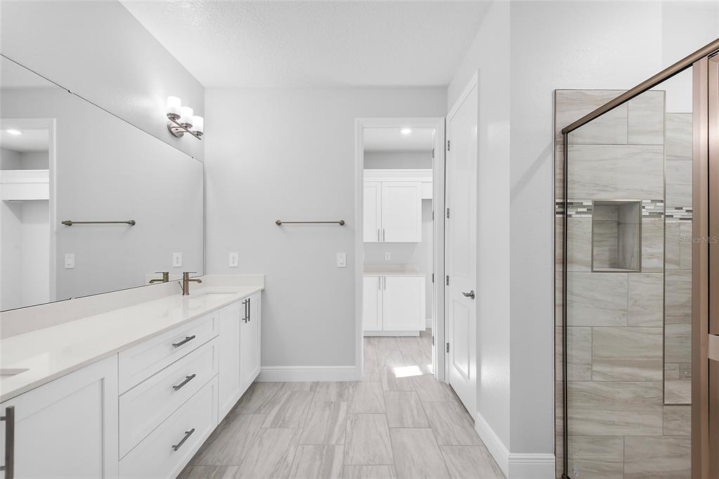 304 North Jungle Road Geneva, FL 32732 - Photo 7 of 49 a spacious bathroom with a double vanity sink a large mirror a shower and a bathtub