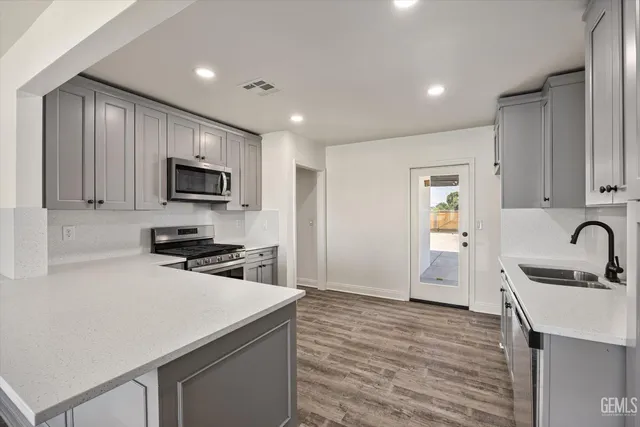 a kitchen with a sink a stove a microwave and cabinets