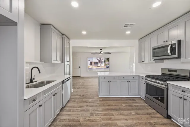 a large kitchen with cabinets stainless steel appliances and a sink