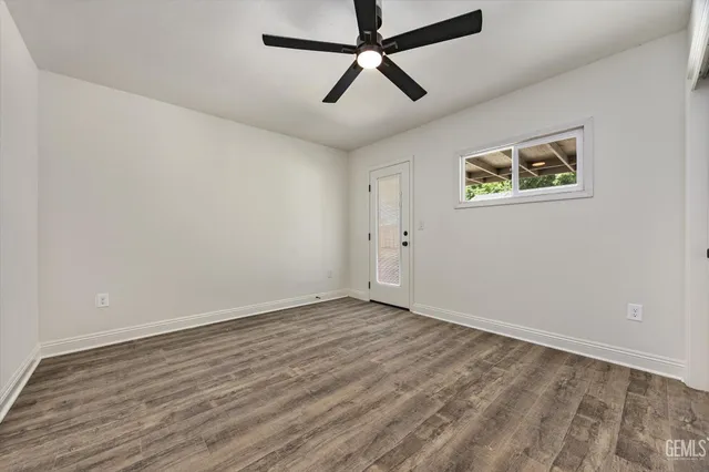 a view of room with wooden floor and ceiling fan