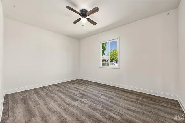 an empty room with a window and a fan