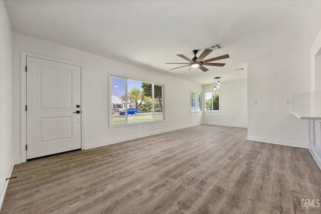 an empty room with window and a ceiling fan
