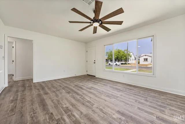 an empty room with windows and ceiling fan view