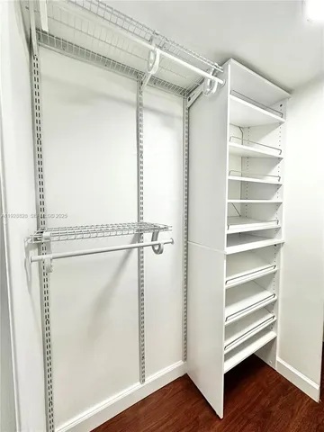 a view of walk in closet with empty racks