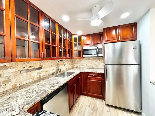 a kitchen with stainless steel appliances granite countertop a refrigerator and a sink
