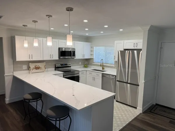 a kitchen with a refrigerator a oven and a sink