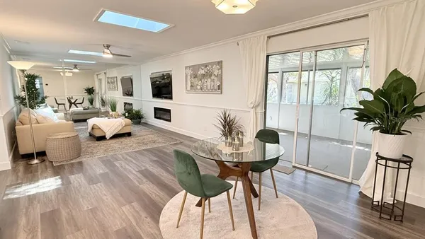 a living room with furniture potted plant and wooden floor
