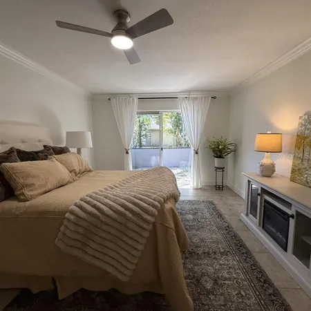 a spacious bedroom with a bed a fireplace and a large window