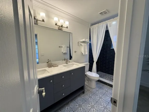a bathroom with a double vanity sink and a mirror
