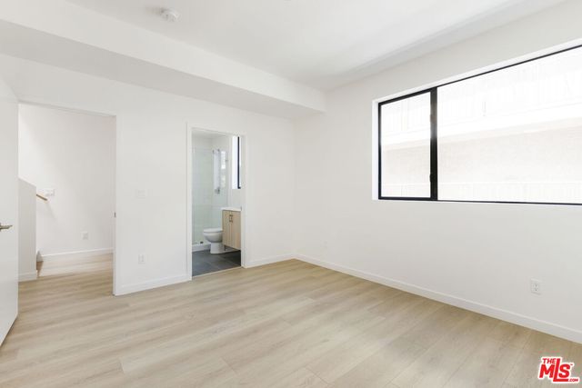 an empty room with windows and closet