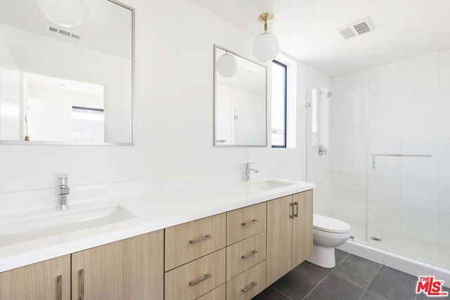 a bathroom with a granite countertop sink a toilet and a mirror