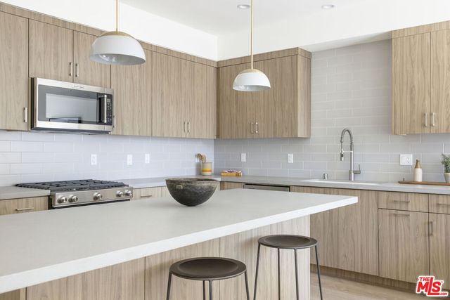 a kitchen with a sink a microwave and cabinets