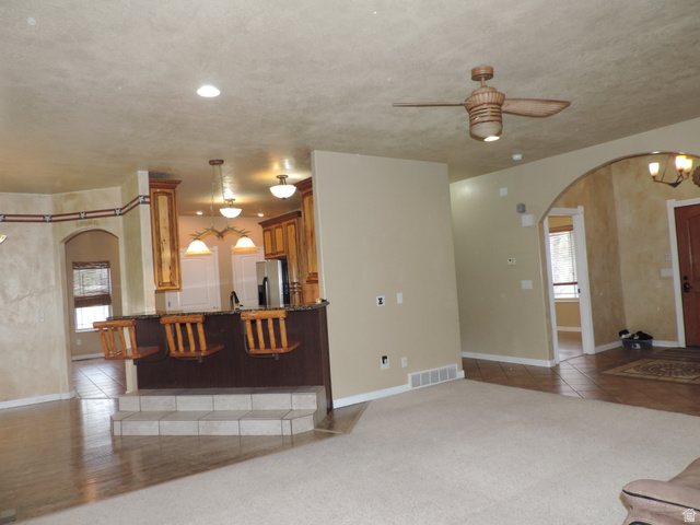 140 North 200 E Street Glenwood, UT 84730 - Photo 5 of 54 Unfurnished living room featuring arched walkways, healthy amount of natural light, ceiling fan, and light tile patterned floors