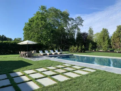 a view of a swimming pool with a table and chairs under an umbrella